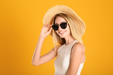 Photo of Beautiful woman in stylish sunglasses on yellow background