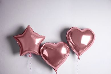 Different balloons near light wall. Festive decor