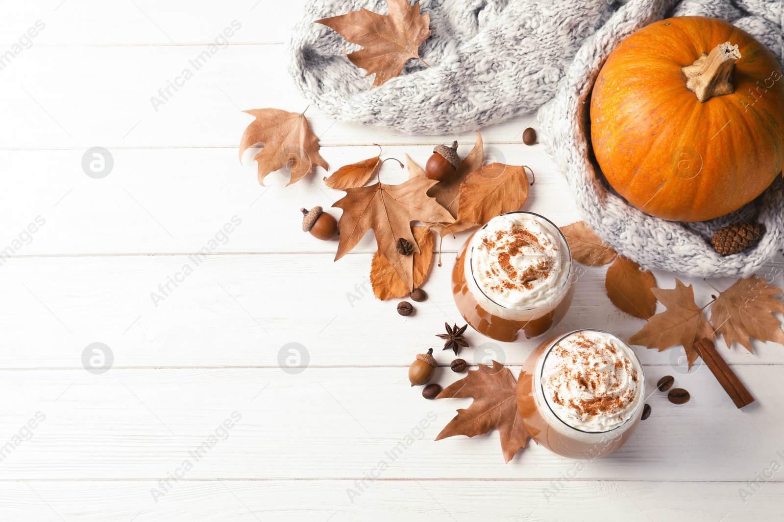 Photo of Flat lay composition with glasses of tasty pumpkin spice latte and space for text on wooden background