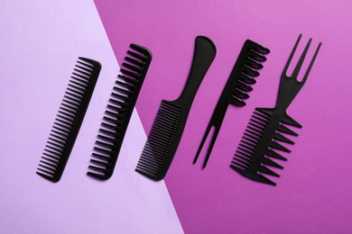 Photo of Set of black combs on color background, flat lay