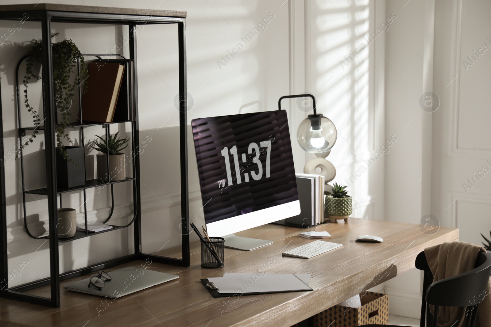 Photo of Modern computer and laptop on wooden desk in room. Interior design