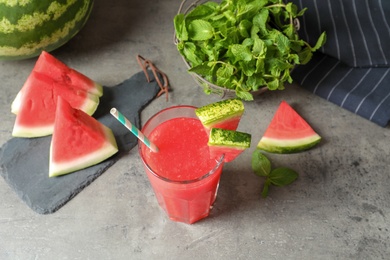 Summer watermelon drink in glass and sliced fruit on table