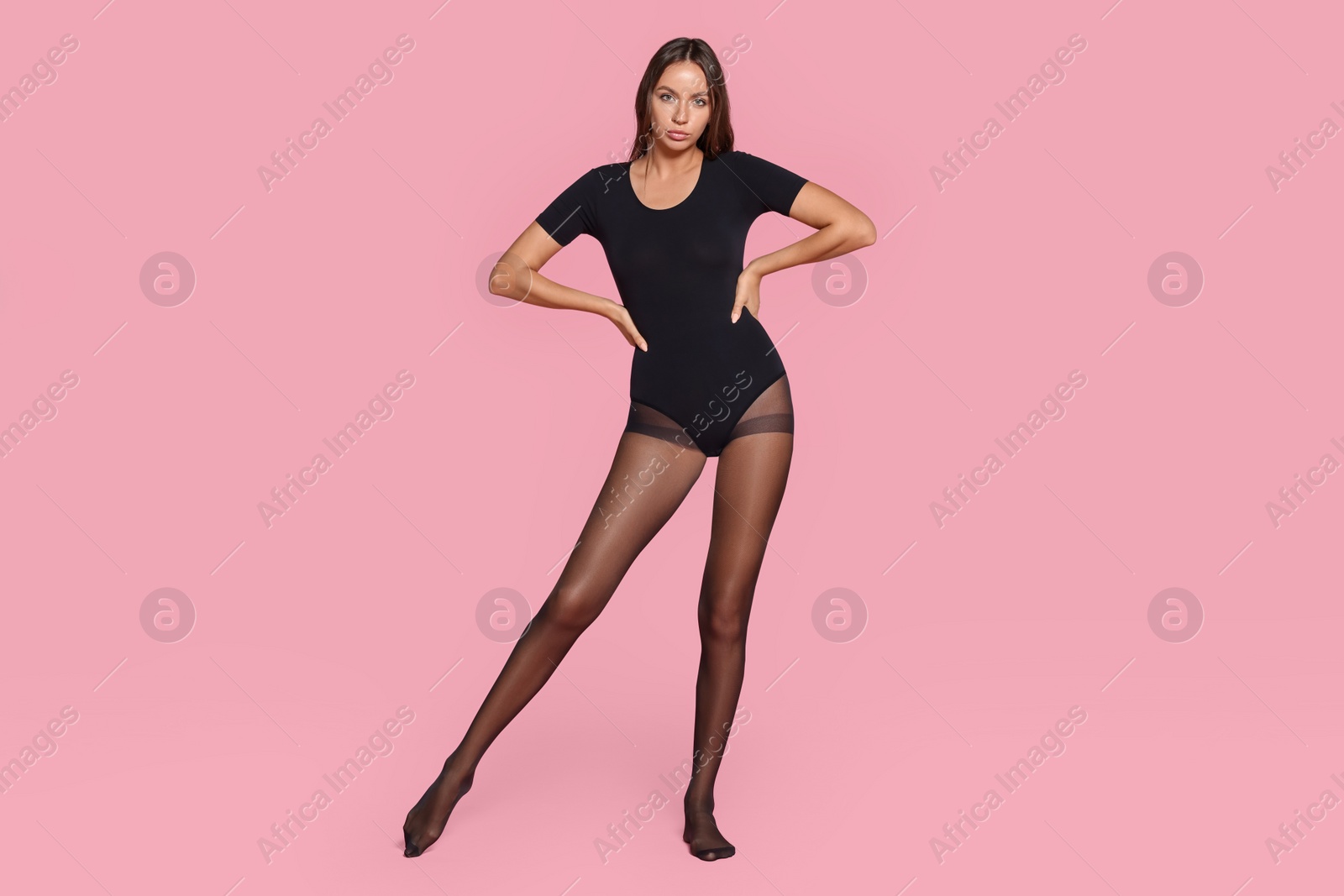 Photo of Beautiful woman wearing tights and bodysuit on pink background