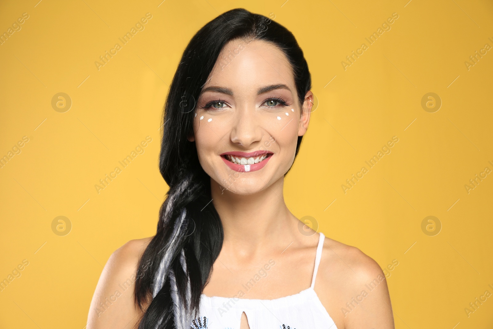 Photo of Portrait of young hippie woman with boho makeup in stylish outfit on color background