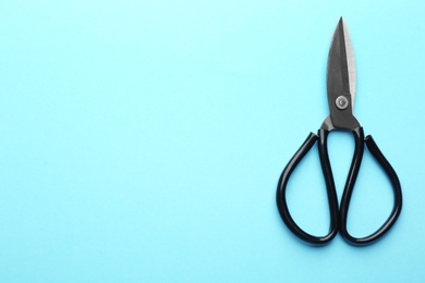 Photo of Pair of sharp scissors on color background, top view. Space for text