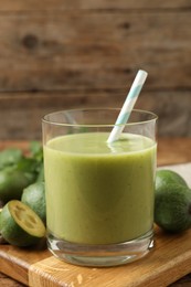 Photo of Fresh feijoa smoothie and fresh fruits on wooden board, closeup