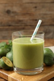 Fresh feijoa smoothie and fresh fruits on wooden board, closeup