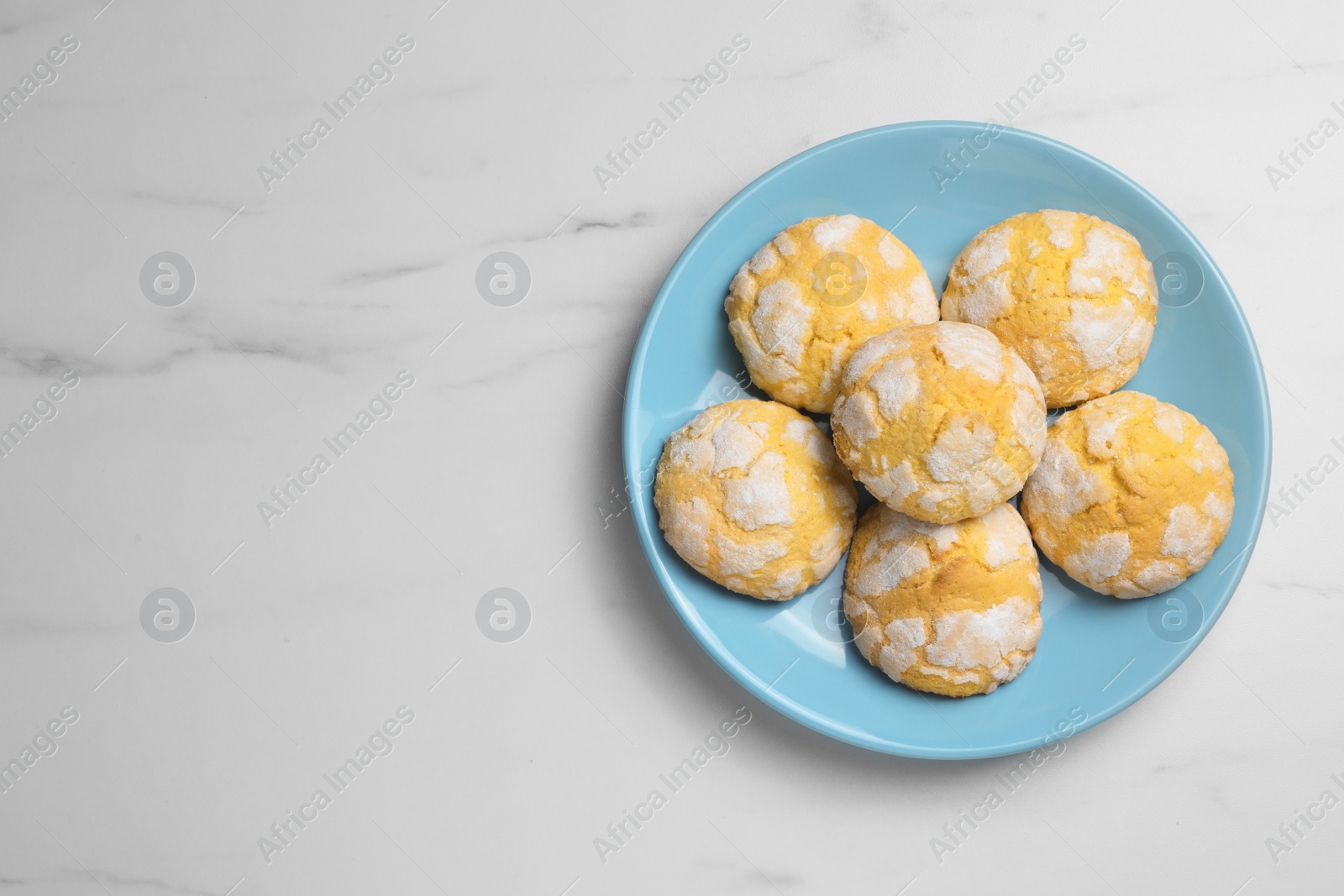 Photo of Plate with delicious lemon cookies on white marble table, top view. Space for text