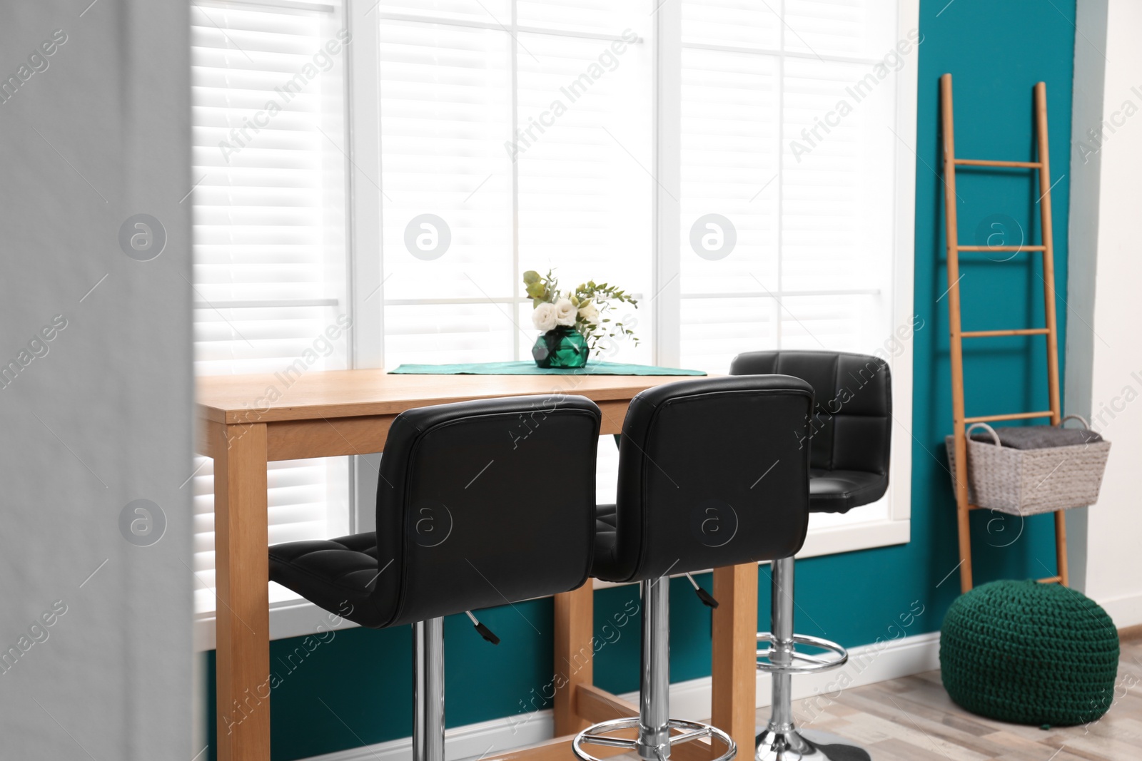Photo of Elegant room interior with wooden table and bar chairs