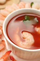 Tasty boiled shrimps with cocktail sauce, chili and parsley on table, closeup