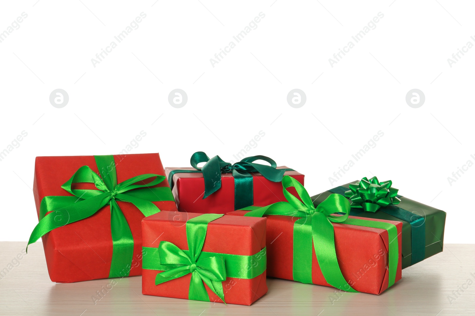 Photo of Red and green gift boxes on wooden table against white background