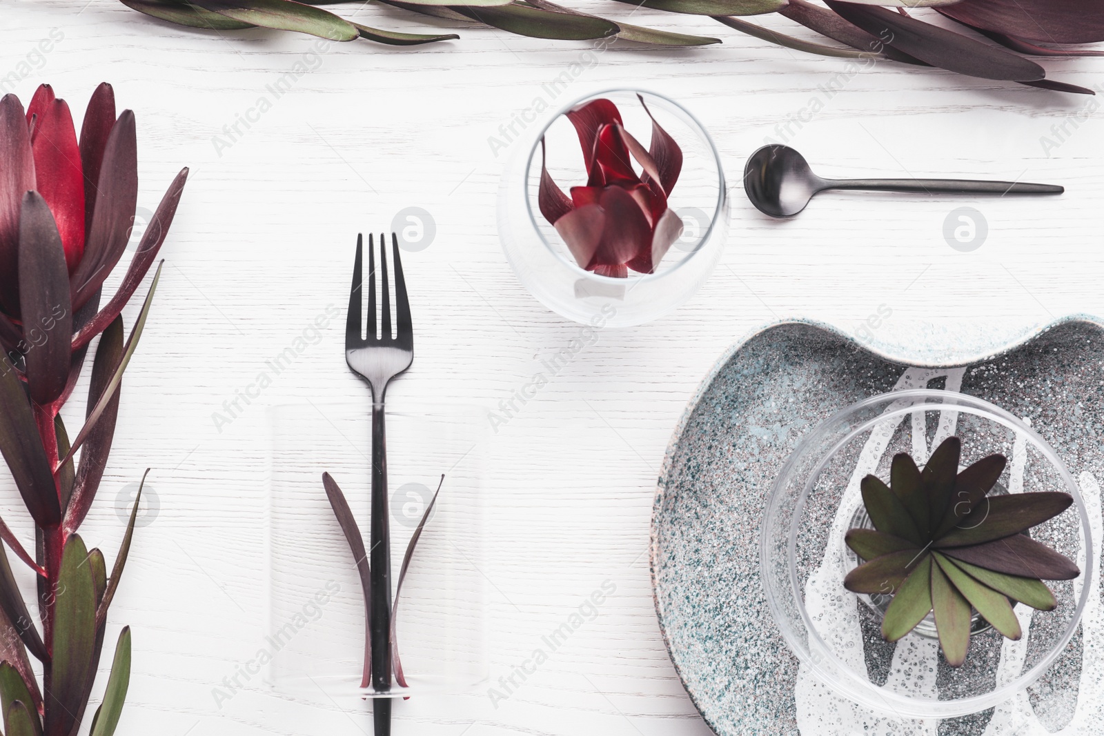 Photo of Elegant table setting with floral decor on white wooden background, flat lay