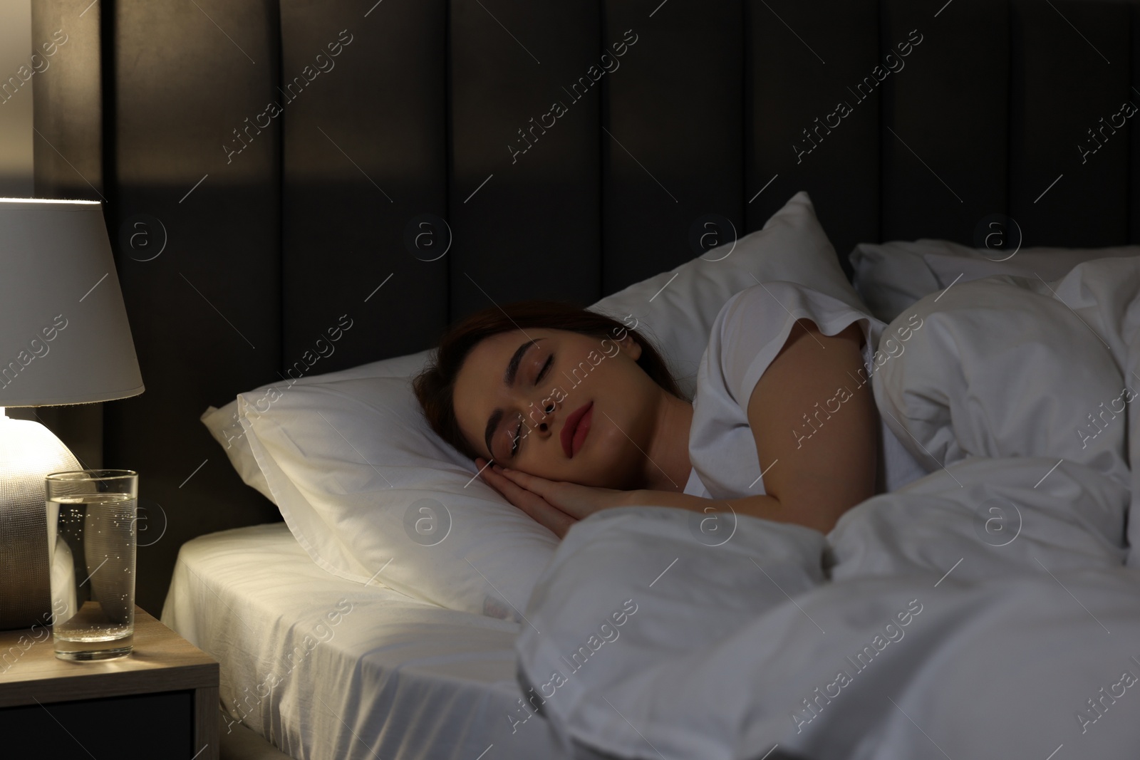 Photo of Beautiful young woman sleeping in bed at night