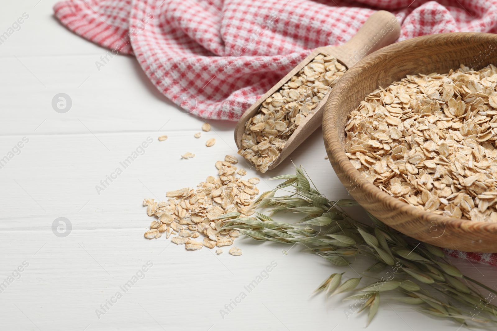 Photo of Oatmeal and branches with florets on white wooden table, space for text