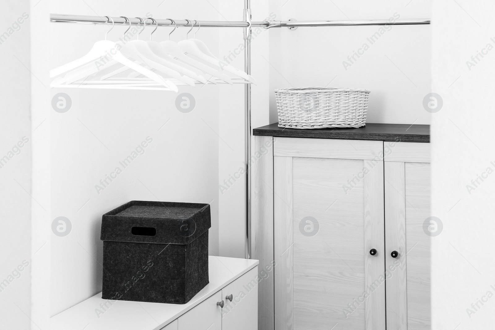 Photo of Dressing room with chest of drawers and rack for clothes