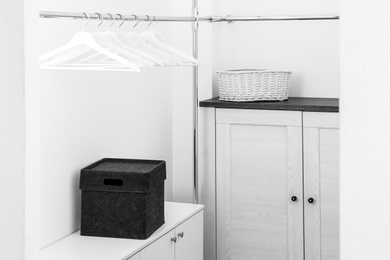 Photo of Dressing room with chest of drawers and rack for clothes