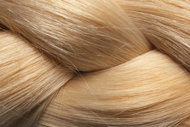 Photo of Healthy braided blond hair as background, closeup