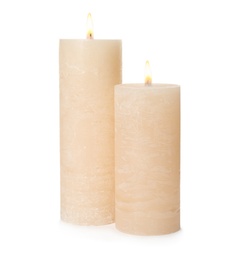 Photo of Two alight wax candles on white background