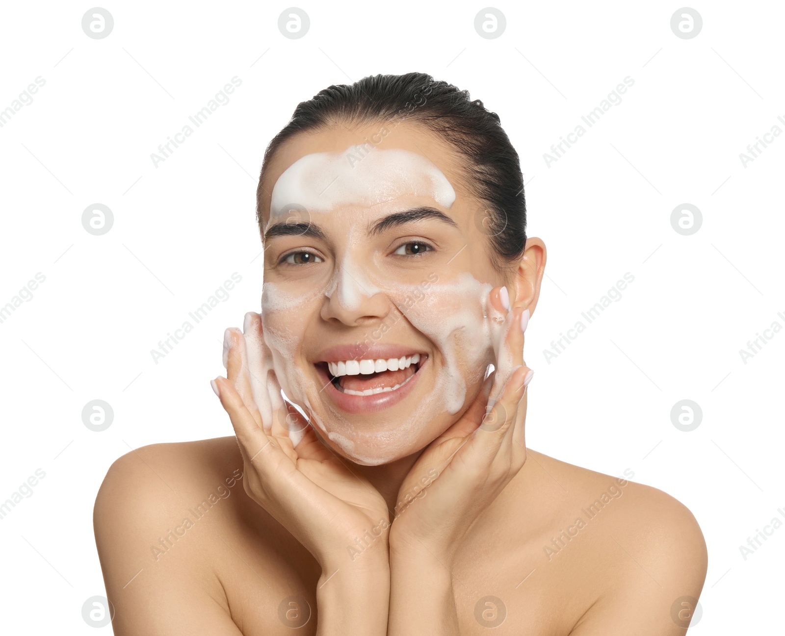 Photo of Happy young woman washing face with cosmetic product on white background