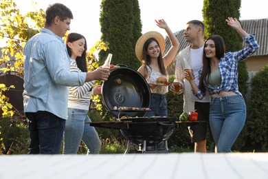 Photo of Group of friends having barbecue party outdoors