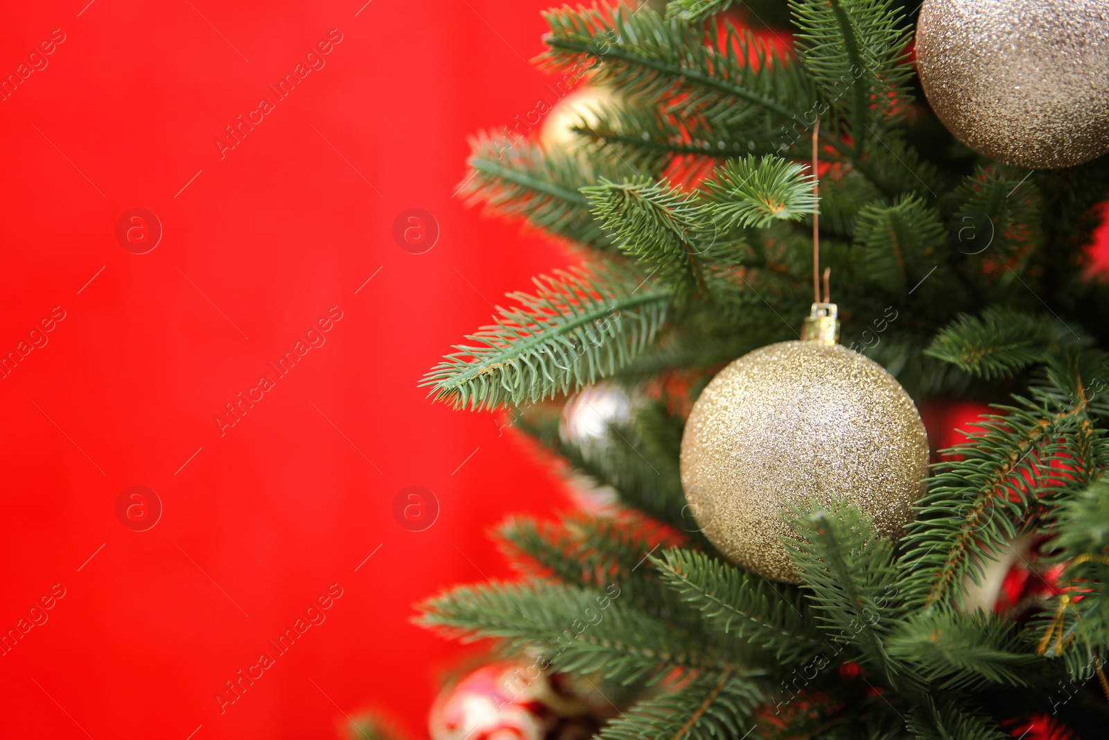 Photo of Beautifully decorated Christmas tree against color background, closeup