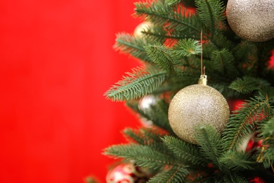 Beautifully decorated Christmas tree against color background, closeup