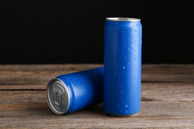 Energy drinks in wet cans on wooden table
