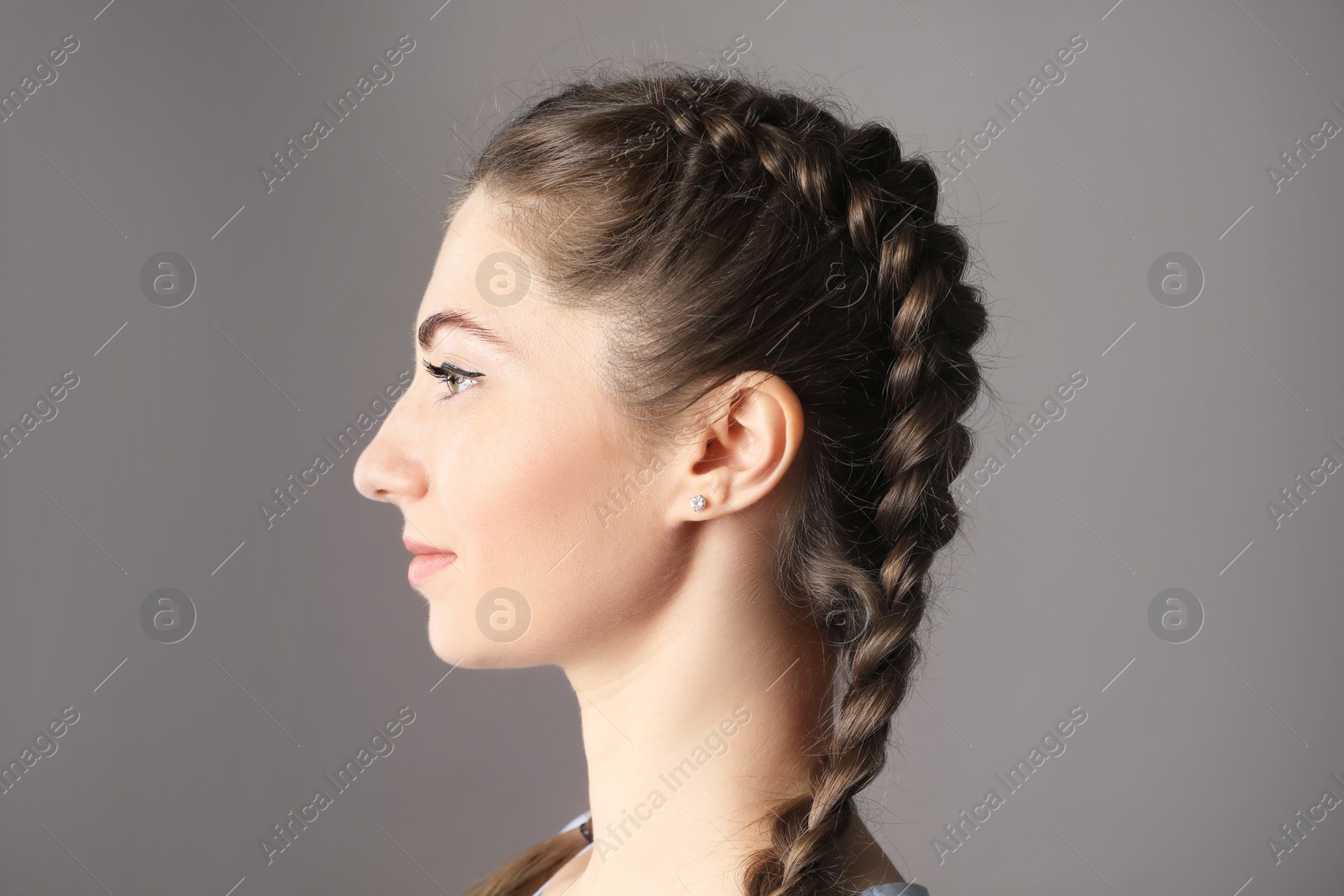 Photo of Woman with braided hair on grey background