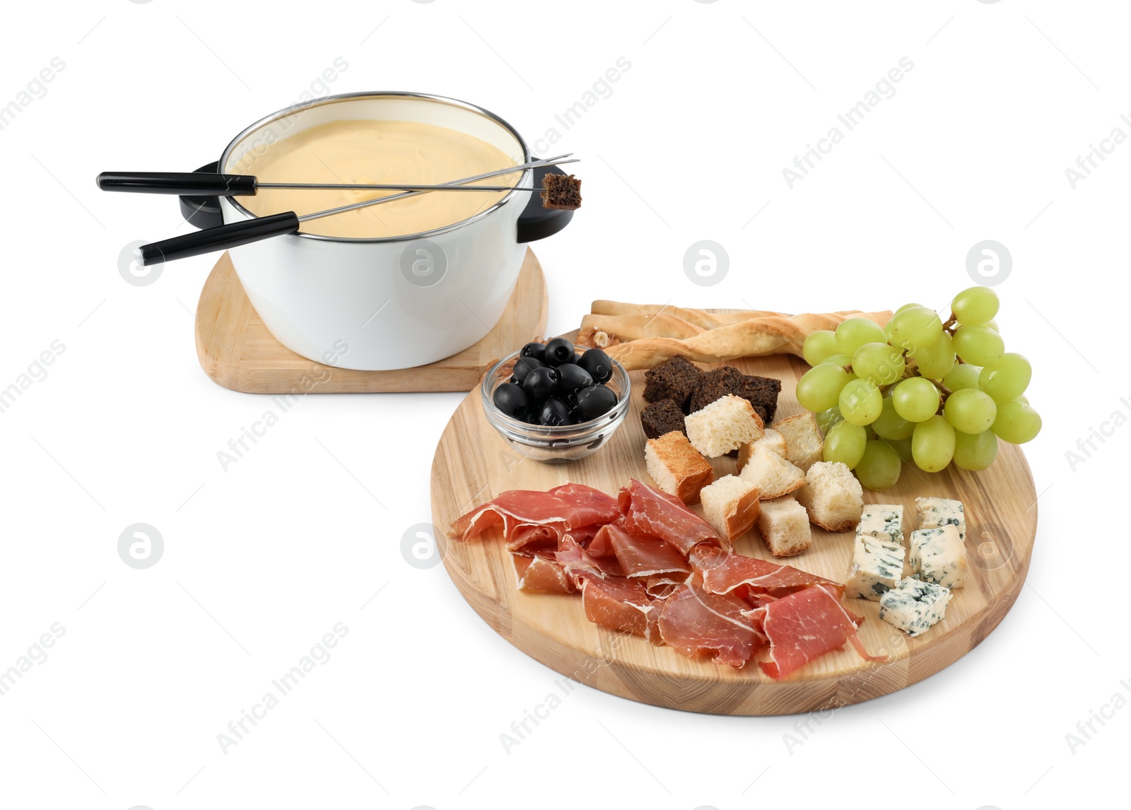 Photo of Fondue with tasty melted cheese, forks and different snacks isolated on white