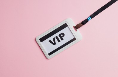 Photo of Plastic vip badge on pale pink background, top view