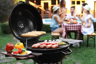 Barbecue grill with sausages and vegetables outdoors