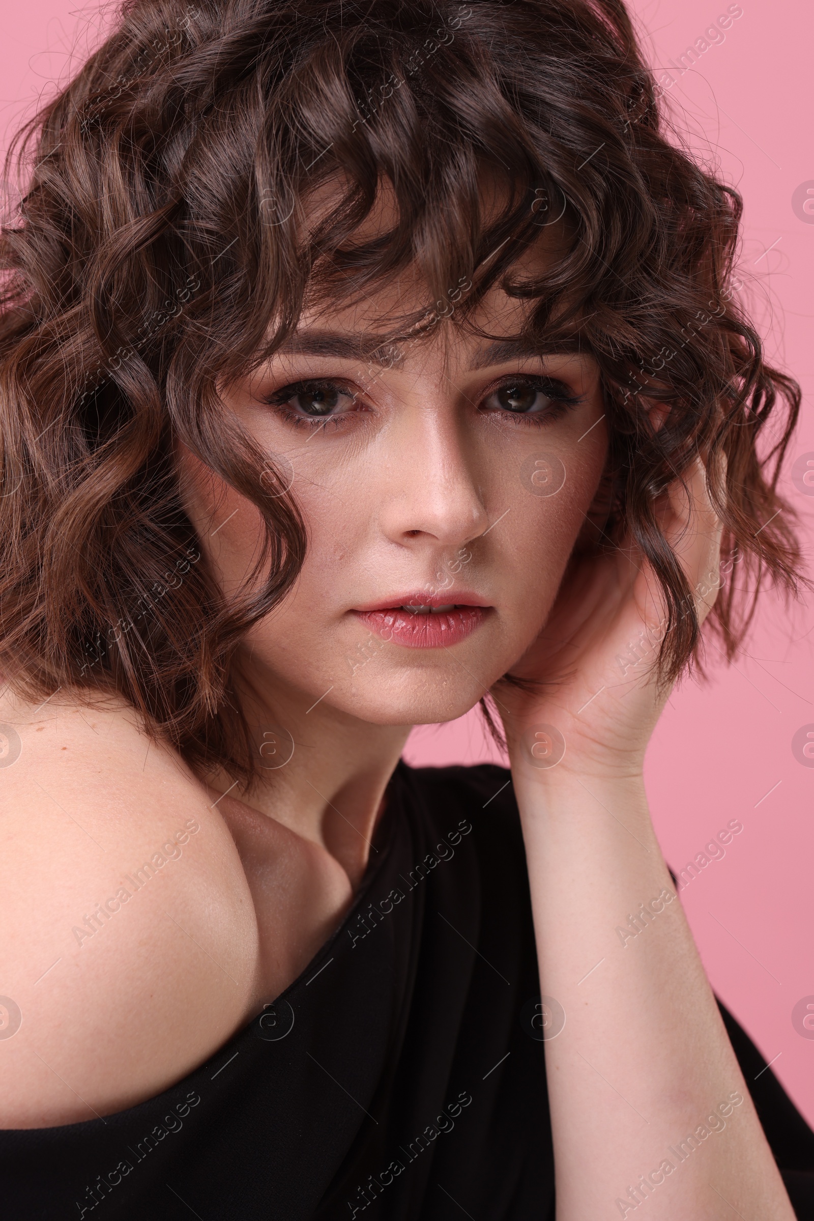 Photo of Portrait of beautiful young woman with wavy hairstyle on pink background