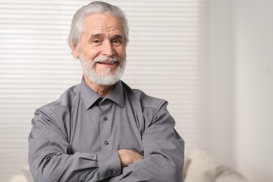 Photo of Portrait of handsome senior man at home. Space for text