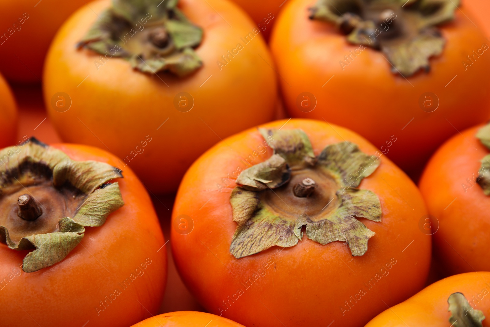 Photo of Delicious ripe juicy persimmons as background, closeup