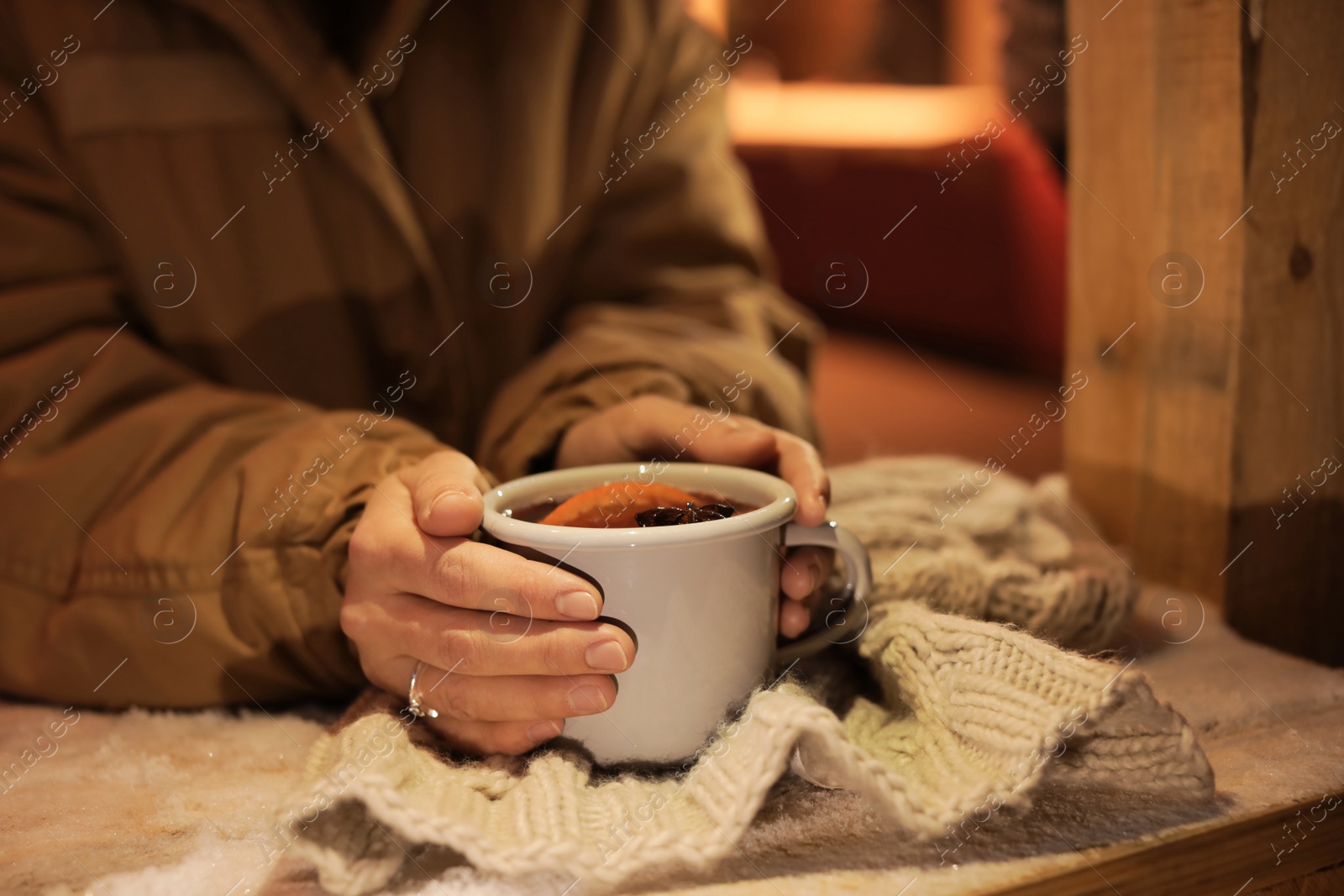 Photo of Woman with cup of mulled wine at table, closeup. Space for text