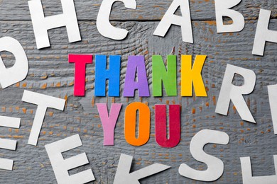 Photo of Phrase Thank You made of colorful letters on grey wooden table, flat lay