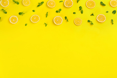 Photo of Lemonade layout with juicy lemon slices and mint on yellow background, top view. Space for text