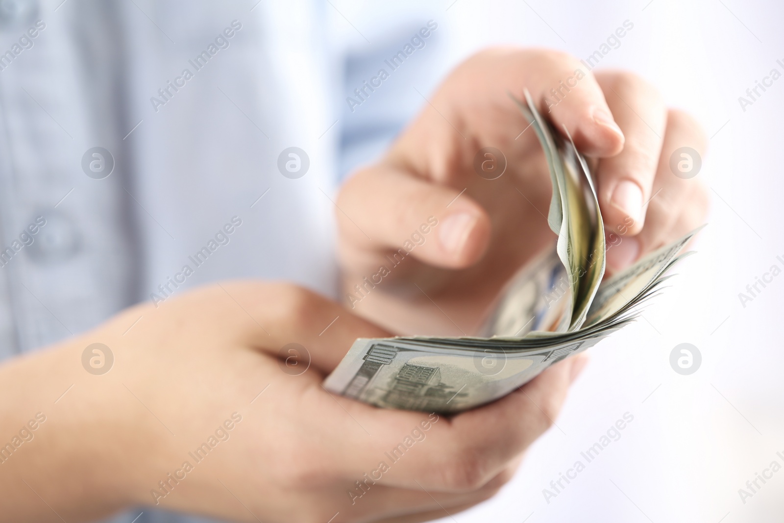 Photo of Woman counting money on blurred background, closeup