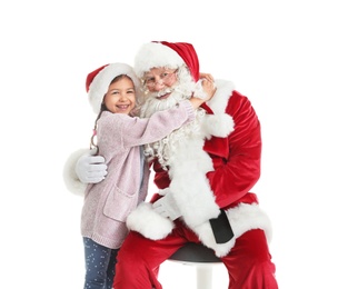 Little girl hugging authentic Santa Claus on white background