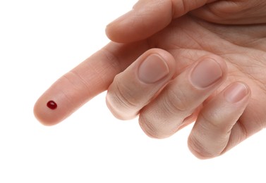 Woman with pricked finger and blood drop on white background, closeup
