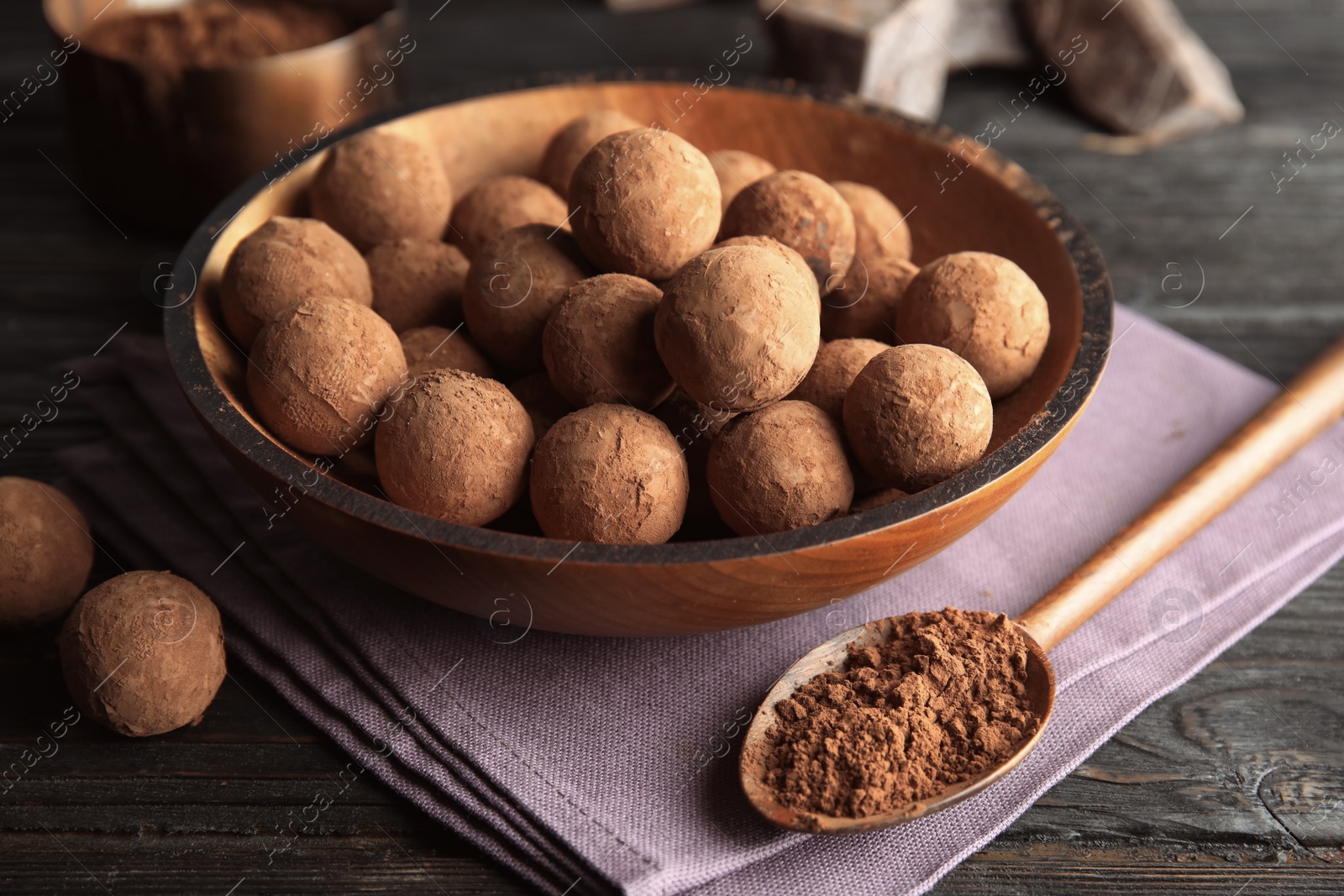 Photo of Plate with chocolate truffles on wooden background