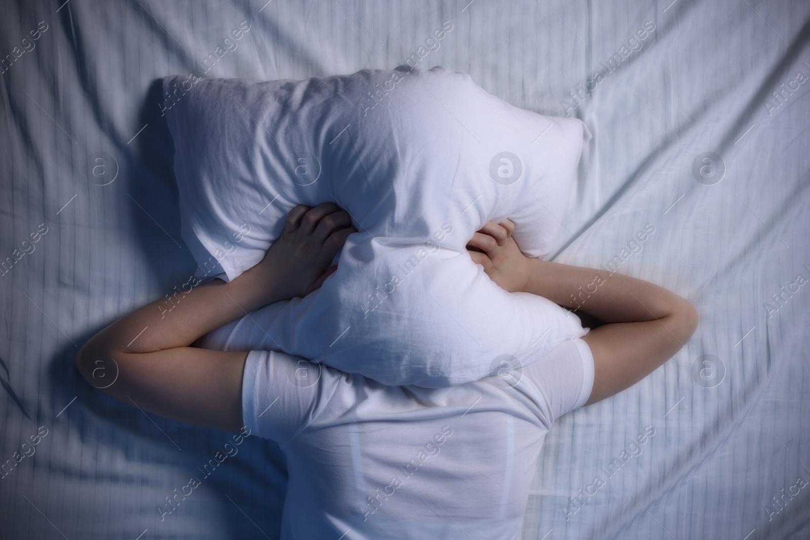 Photo of Young woman suffering from insomnia in bed, top view