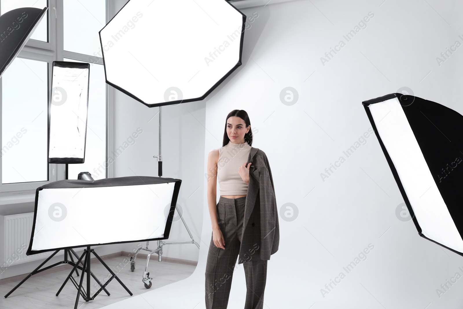 Photo of Beautiful young model posing in modern studio. Professional photo session