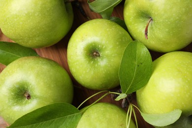 Photo of Fresh ripe green apples and leaves on wooden background, flat lay