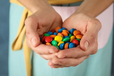 Woman holding many tasty glazed candies, closeup