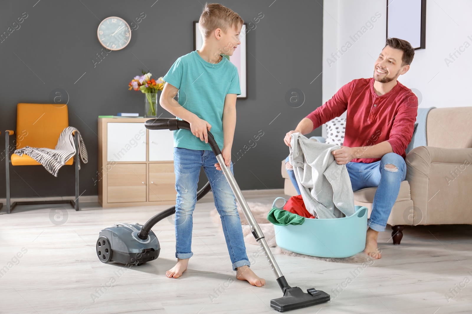 Photo of Little boy and his dad cleaning their house together