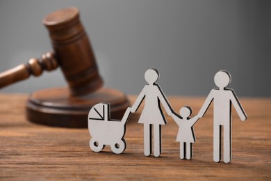 Photo of Family law. Figure of parents with children and gavel on wooden table