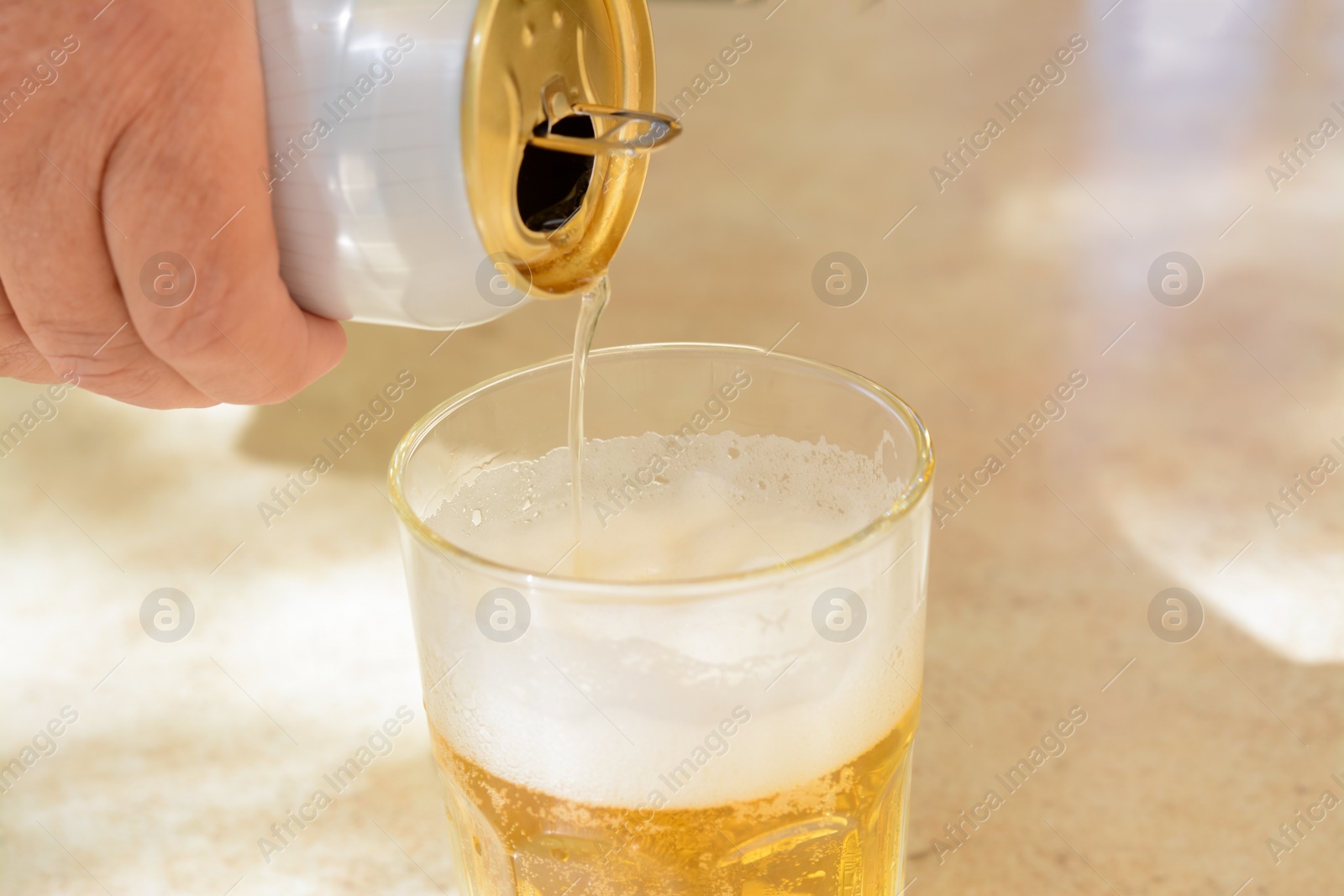 Photo of Man pouring beer from can into glass at table, closeup. Space for text