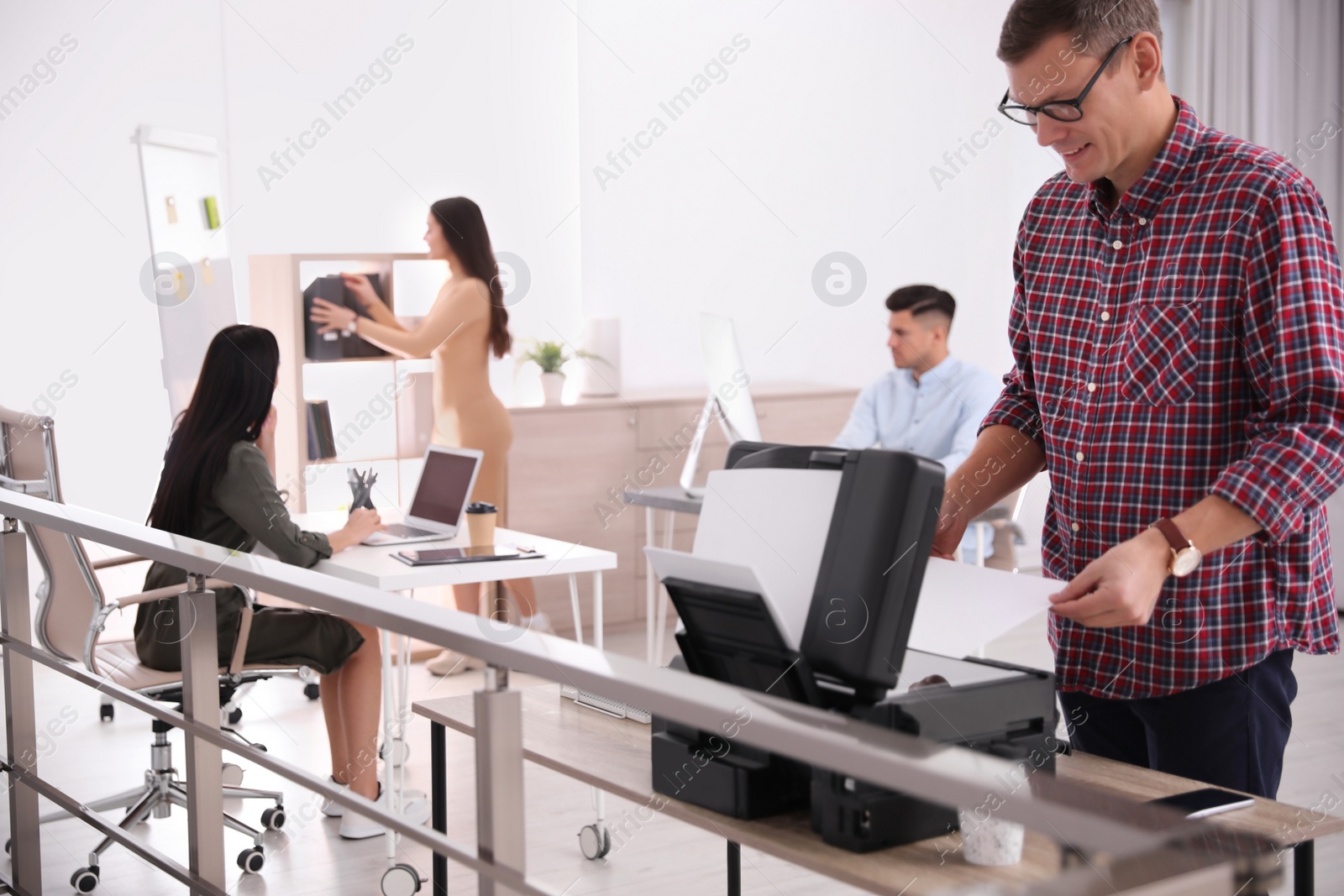 Photo of Employee using new modern printer in office