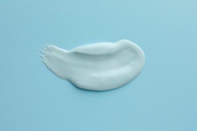 Sample of face mask on light blue background, top view